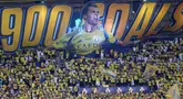 Publik Al-Nassr merayakan rekor gol ke-900 milik Cristiano Ronaldo saat laga lanjutan Liga Arab melawan Al-Ahli yang berlangsung di Al-Awwal Stadium, Riyadh, Jumat (13/09/2024) waktu setempat. Para suporter terlihat membentangkan banner raksasa bertuliskan 900 goals dengan gambar sang pemain. (AFP/Fayez Nureldine)