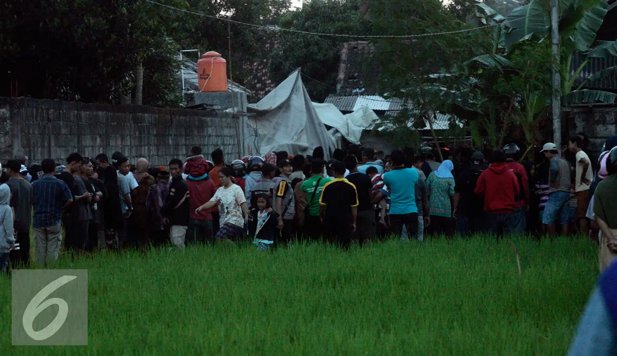 Warga berkerumun untuk melihat helikopter yang jatuh di Dusun Kowang, Sleman (8/7). Heli jatuh setelah melakukan penerbangan dari Solo menuju Yogyakarta. (Liputan6.com/Boy Harjanto)
