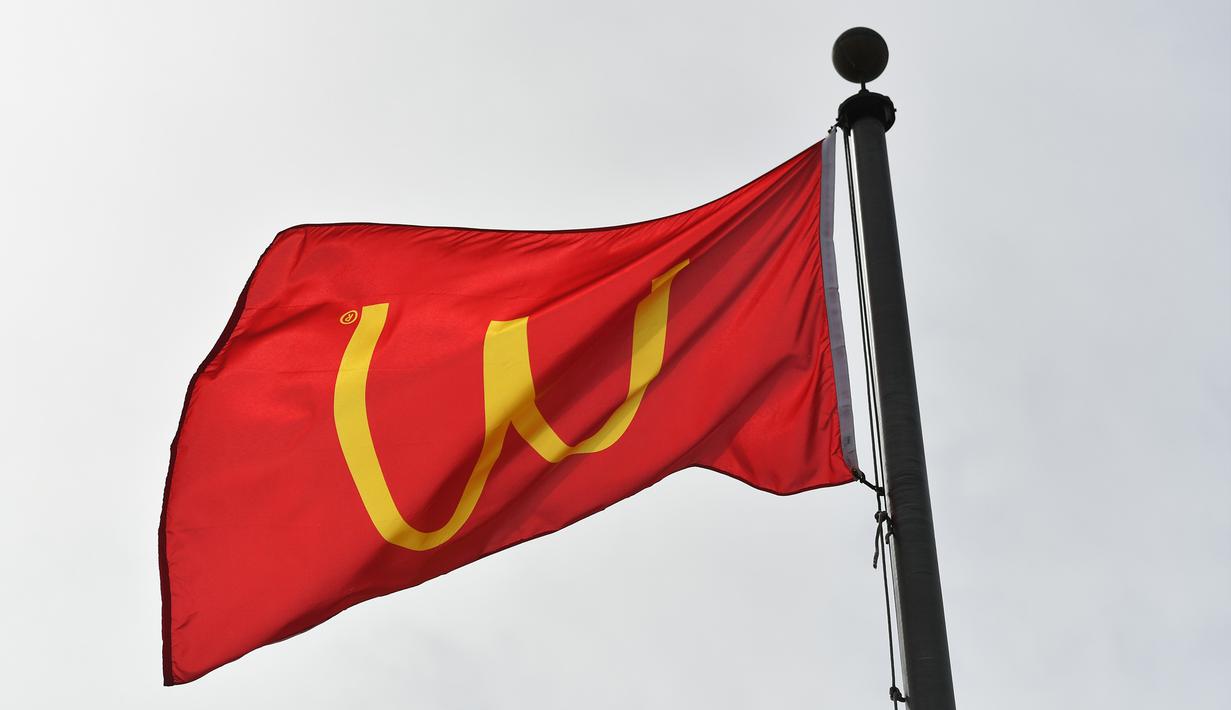 Bendera restoran cepat saji McDonald's dengan logo terbalik yang dikbarkan di Lynwood, California (8/3). Logo tersebut dibalik dari huruf M menjadi huruf W untuk peringati Hari Perempuan Internasional. (Neilson Barnard / Getty Images / AFP)