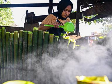 Seorang pekerja memasak Lemang untuk berbuka puasa Ramadan, Banda Aceh pada tanggal 29 Maret 2024. (CHAIDEER MAHYUDDIN/AFP)