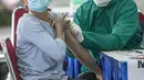 Petugas medis menyuntikkan vaksin COVID-19 kepada pedagang di Pasar Induk Kramat Jati, Jakarta Timur, Selasa (9/3/2021). Penyuntikan vaksin tahap pertama ini menargetkan 1.000 peserta. (Liputan6.com/Faizal Fanani)