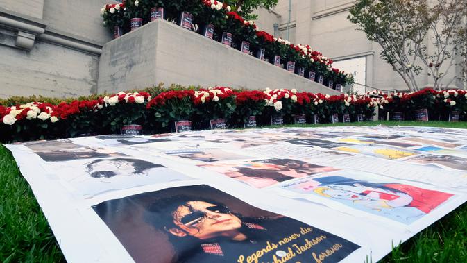 Karya seni dan bunga-bunga berjejer di luar tempat peristirahatan terakhir Michael Jackson di mausoleum Holly di Terrace Forest Lawn Cemetery, California, Selasa (25/6/2019). Tepat pada hari ini sepuluh tahun yang lalu berita kematian King of Pop Michael Jackson mengguncang dunia. (AP/Richard Vogel)