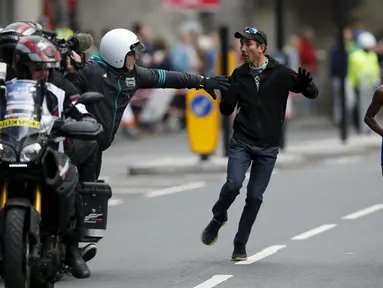 Seorang penonton masuk lintasamn saat pelari Kenya, Jemima Sumgong beraksi di kejuaraan Virgin Money London Marathon, London, (24/4/2016). (Reuters/Peter Cziborra)