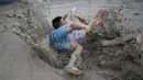 Turis bergulat di kubangan lumpur saat mengikuti Festival lumpur Boryeong di pantai Daecheon, Boryeong, Korea Selatan, (15/7). Festival ini digelar setiap tahun sekali pada bulan Juli. ( REUTERS/Kim Hong-Ji)