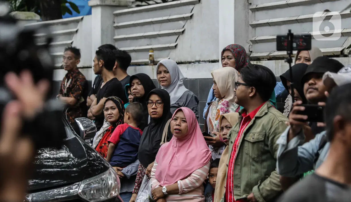 Warga saat berada di depan rumah duka almarhum Ashraf Sinclair di kawasan Pejaten Barat IV, Jakarta, Selasa (18/2/2020). Suami Bunga Citra Lestari, Ashraf Sinclair, meninggal dunia diduga akibat serangan jantung pada Selasa 18 Februari 2020 pukul 3.40 pagi. (Liputan6.com/Faizal Fanani)