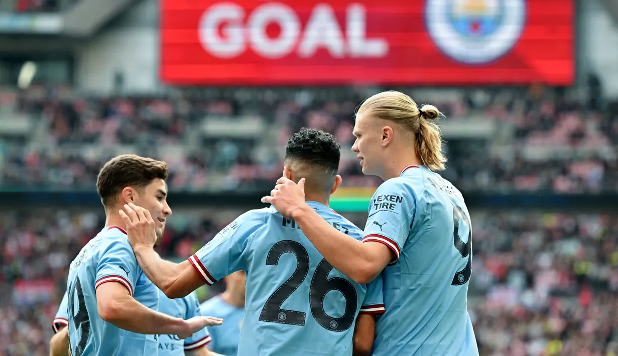 Pemain Manchester City merayakan gol yang dicetak oleh Riyad Mahrez (tengah) pada laga semifinal Piala FA 2022/2023 melawan Sheffiled United di Stadion Wembley, London, Minggu (23/04/2023) WIB. The Cityzens sukses meraih kemenangan melalui hattrick Mahrez. (AFP/Glyn Kirk)