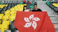 Suporter sekaligus orang tua dari pemain Timnas Hong Kong, Ryan Lee yang datang langsung ke Stadion Geora Bung Tomo, Rabu (14/9/2022). (Bola.com/Wahyu Pratama)