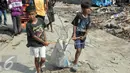 Dua bocah membawa besi bekas hasil mengais di bongkaran Pasar Ikan Luar Batang, Jakarta, Kamis (14/4). Besi bekas tersebut dijual warga kepada pengepul dengan harga Rp.2.500. (Liputan6.com/Helmi Afandi)