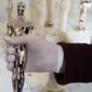 Seorang spesialis pembuat Piala Oscar, Paul Pisoni menunjukan Piala Oscar yang sedang dibuatnya di tempat produksi Polich Tallix Fine Art Foundry, New York, AS (13/1). Piala Oscar tersebut terbuat dari perunggu dan disepuh emas 24 karat. (AFP/Don Emmert)