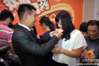 Wang menyuapkan hot dog pada Chen setelah wanita itu mau menikah dengannya.