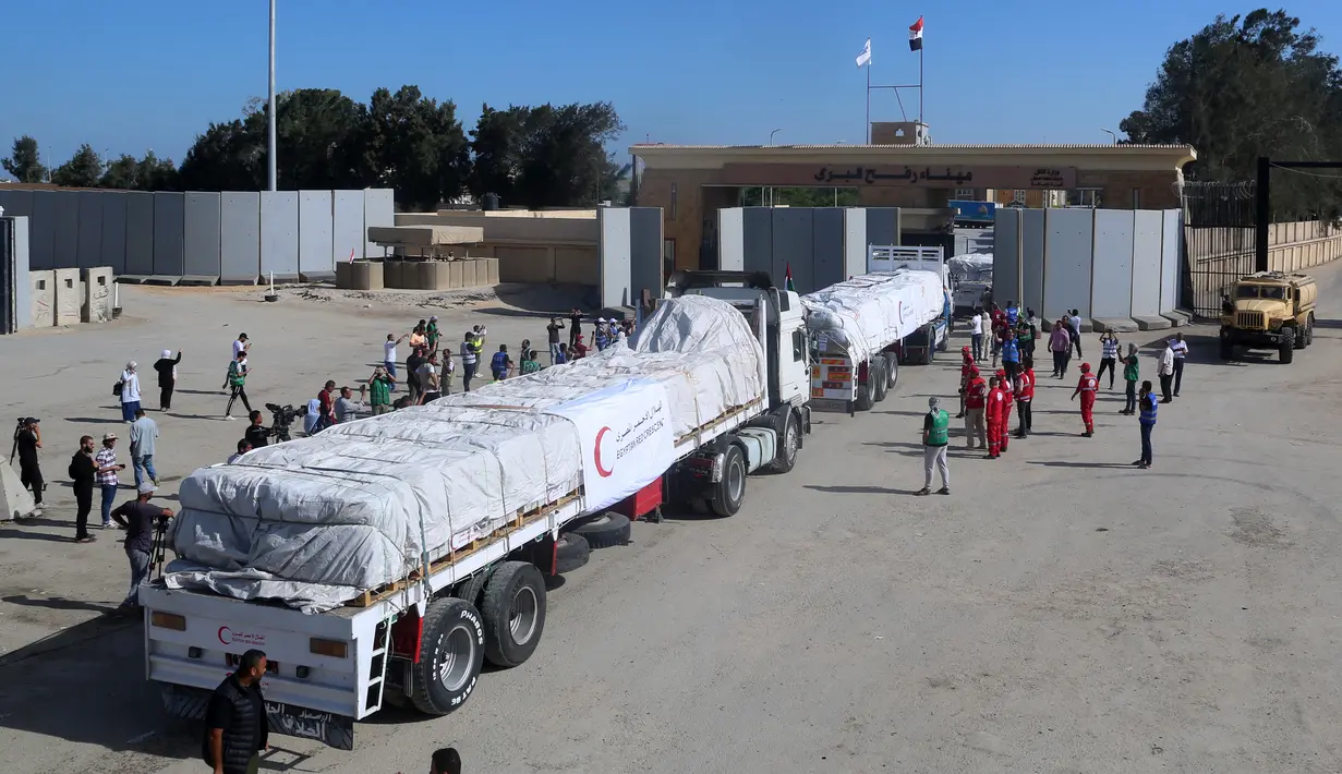 Orang-orang di perbatasan Rafah sisi Mesir bersorak saat konvoi truk yang membawa bantuan kemanusiaan melintasi Jalur Gaza, Sabtu (21/10/2023). (Mohammed Assad / AFP)