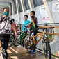 Warga melewati jembatan penyeberangan orang saat berolahraga menggunakan sepeda di sepanjang Jalan Sudirman, Jakarta, Minggu (26/7/2020). Perluasan jalur sepeda sementara dilakukan sebagai dampak peniadaan hari bebas kendaraan bermotor (HBKB) di Jalan Sudirman-Thamrin. (Liputan6.com/Faizal Fanani)