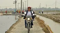 Jokowi mengendarai motor trail saat meninjau tambang udang di Muara Gembong, Bekasi. (Liputan6.com/Facebook Jokowi)