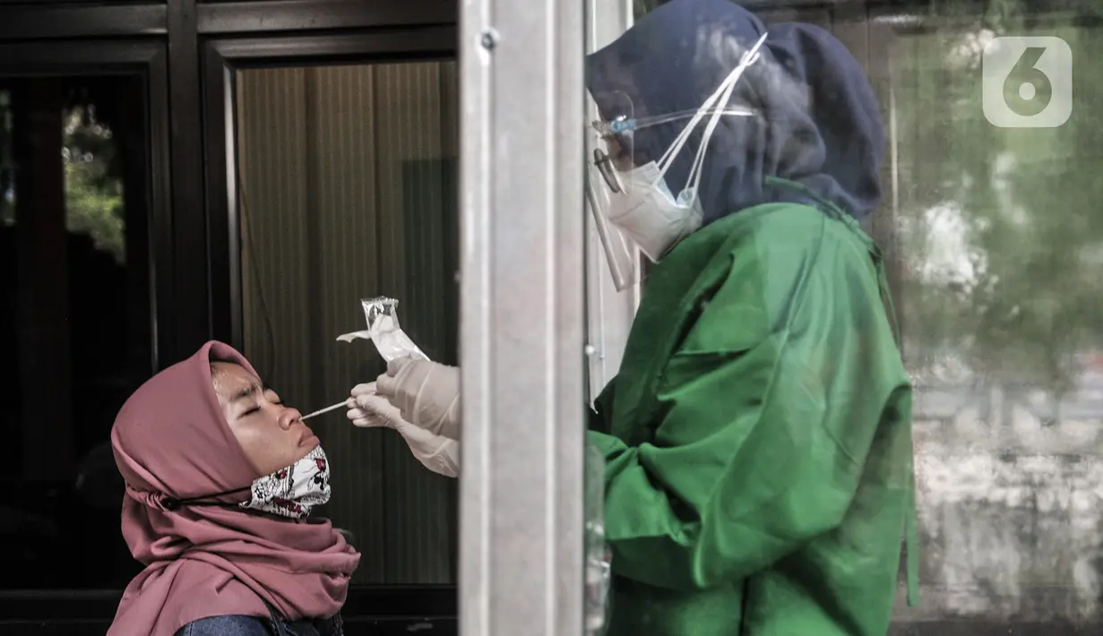 Tenaga kesehatan saat melakukan tes antigen di Terminal Kampung Rambutan, Jakarta, Minggu (3/1/2021). Pengelola Terminal Kampung Rambutan menyediakan tes antigen bagi penumpang yang baru tiba jika tidak memiliki surat kesehatan dengan harga Rp150 ribu per orang. (merdeka.com/Iqbal S. Nugroho)