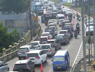 Kondisi lalu lintas saat saat uji coba sistem kanalisasi 2-1 Jalur Puncak di kawasan Gadog, Bogor, Jawa Barat, Minggu (27/10/2019). BPTJ bersama Pemkab dan Polres Bogor melakukan uji coba kanalisasi 2-1 Jalur Puncak pada 27 Oktober dan 3 November 2019. (merdeka.com/Arie Basuki)