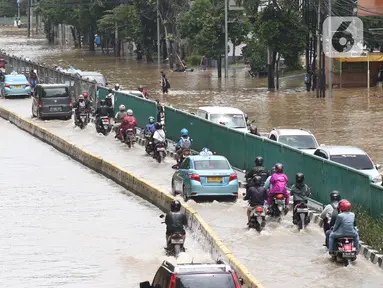 Sejumlah pengendara nekat menerobos genangan banjir di Jalan Gunung Sahari Jakarta, Selasa (25/2/2020). Hujan yang mengguyur Jakarta sejak Senin (24/2) malam membuat sejumlah kali meluap dan menyebabkan banjir. (Liputan6.com/Helmi Fithriansyah)