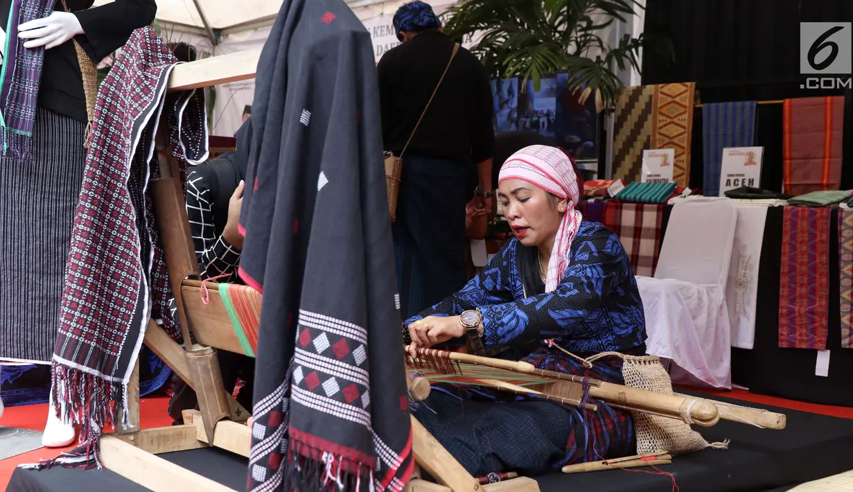 Perajin memeragakan proses penenunan kain di Festival Sarung Indonesia 2019, Plaza Tenggara Kompleks GBK, Jakarta, Minggu (3/3). Festival ini untuk menghidupkan kesadaran generasi muda akan kekayaan budaya Indonesia. (Liputan6.com/Helmi Fithriansyah)