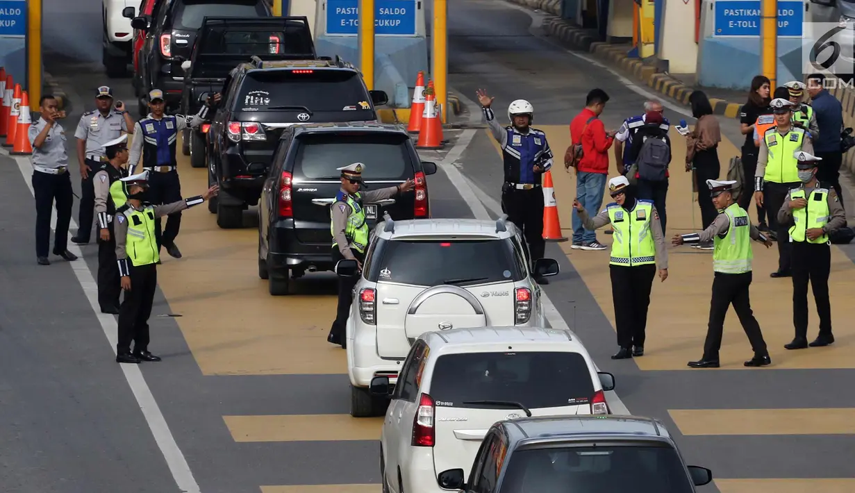 Petugas mengarahkan kendaraan berplat genap berputar balik di Gerbang Tol Bekasi Barat 1, Bekasi, Jawa Barat, Selasa (13/3). Hari kedua penerapan ganjil genap, masih banyak kendaraan berputar balik di gerbang tol tersebut. (Liputan6.com/Arya Manggala)