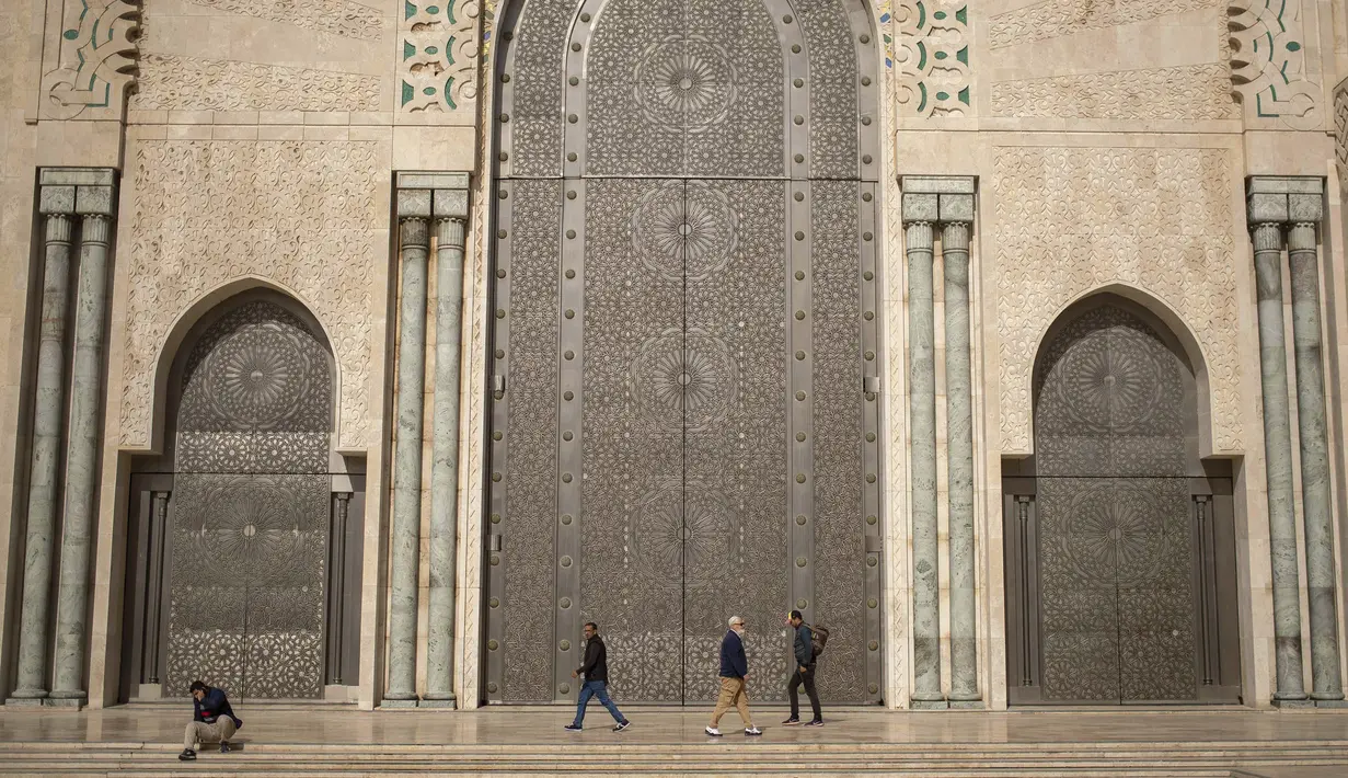 Umat Muslim berjalan setelah melaksanakan salat Jumat di luar masjid Hassan II, salah satu yang terbesar di Afrika, di Casablanca, Maroko (7/2/2020). Masjid ini disebut-sebut sebagai yang terbesar kedua di dunia setelah Masjidil Haram di Kota Mekkah. (AP Photo/Mosaab Elshamy)
