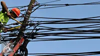 Petugas PLN mengecek instalasi kabel di tiang listrik milik PLN, Jakarta (26/2). Mulai 28 Februari 2016, PLN berencana membongkar perangkat atau jaringan telematika yang memanfaatkan tiang listrik di Jakarta tanpa izin. (Liputan6.com/Immanuel Antonius)