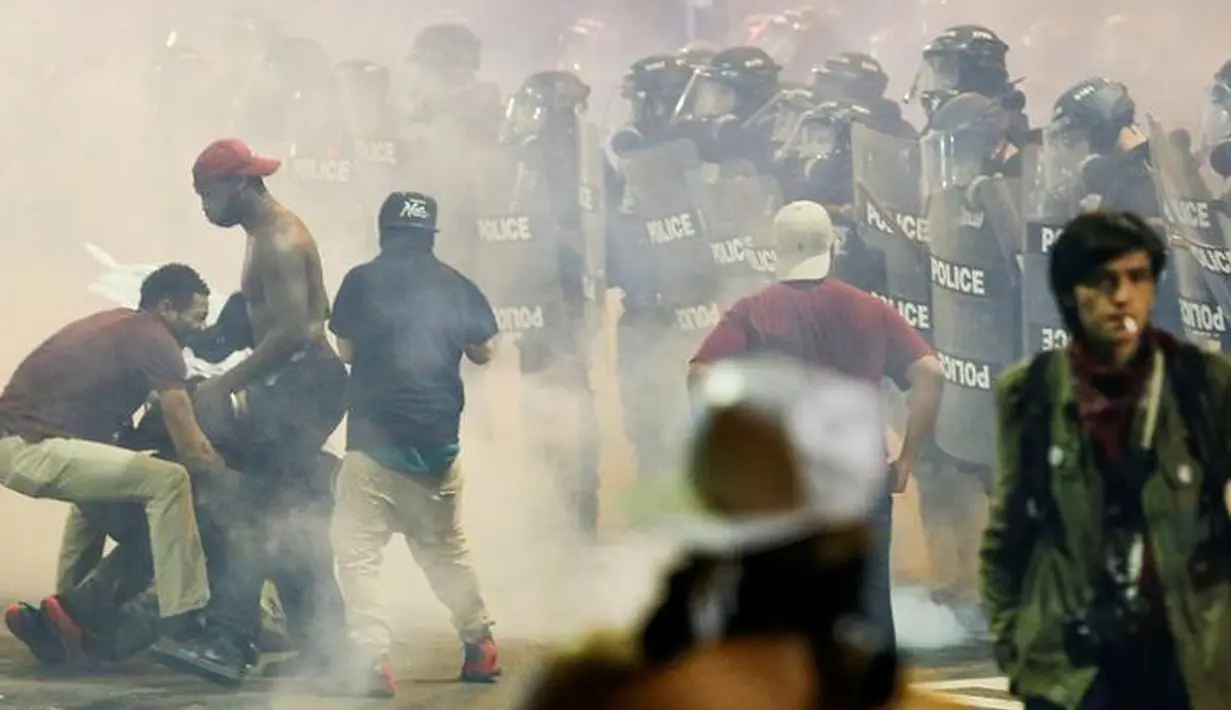 Pengunjuk rasa menghindari gas air mata saat demo di daerah Charlotte, North Carolina, AS, Rabu (21/9). Pengunjuk rasa protes atas penembakan pria kulit hitam yang dilakukan oleh polisi. (REUTERS/Jason Miczek)