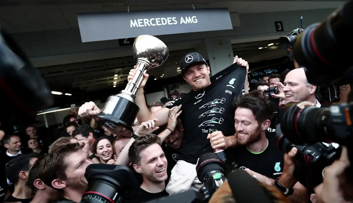 Pebalap Mercedes, Nico Rosberg, merayakan kemenangan bersama kru Mercedes pada balapan F1 GP Jepang di Sirkuit Suzuka, Minggu (9/10/2016). (AFP/Behrouz Mehri)