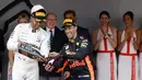 Pembalap Mercedes Lewis Hamilton menuangkan sampanye ke sepatu pembalap Red Bull Daniel Ricciardo usai balapan Grand Prix Monaco Formula 1, Monaco (27/5). Ricciardo saat ini menempati posisi kelima klasemen. (AP/Luca Bruno)