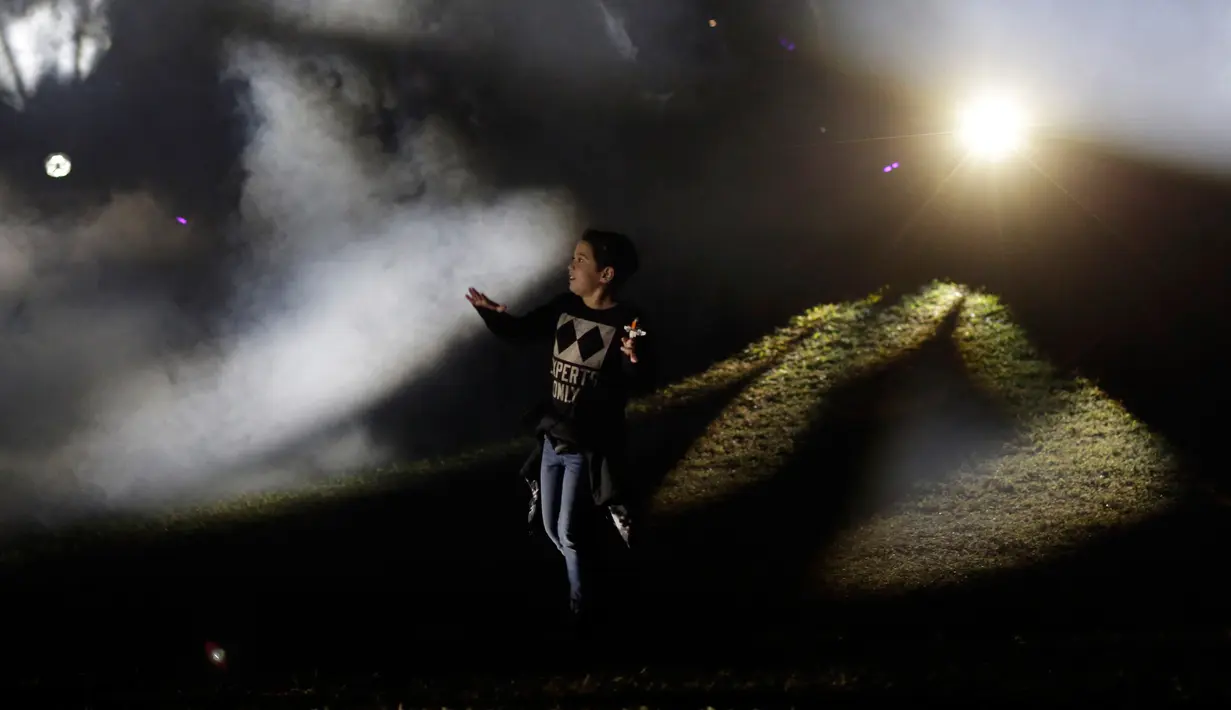 Seorang bocah bermain di NightGarden di Fairchild Tropical Botanic Garden, Miami, AS, Kamis (29/11). Acara ini menampilkan display lampu, hologram, pemetaan proyeksi 3D, video dan musik. (AP Photo/Lynne Sladky)