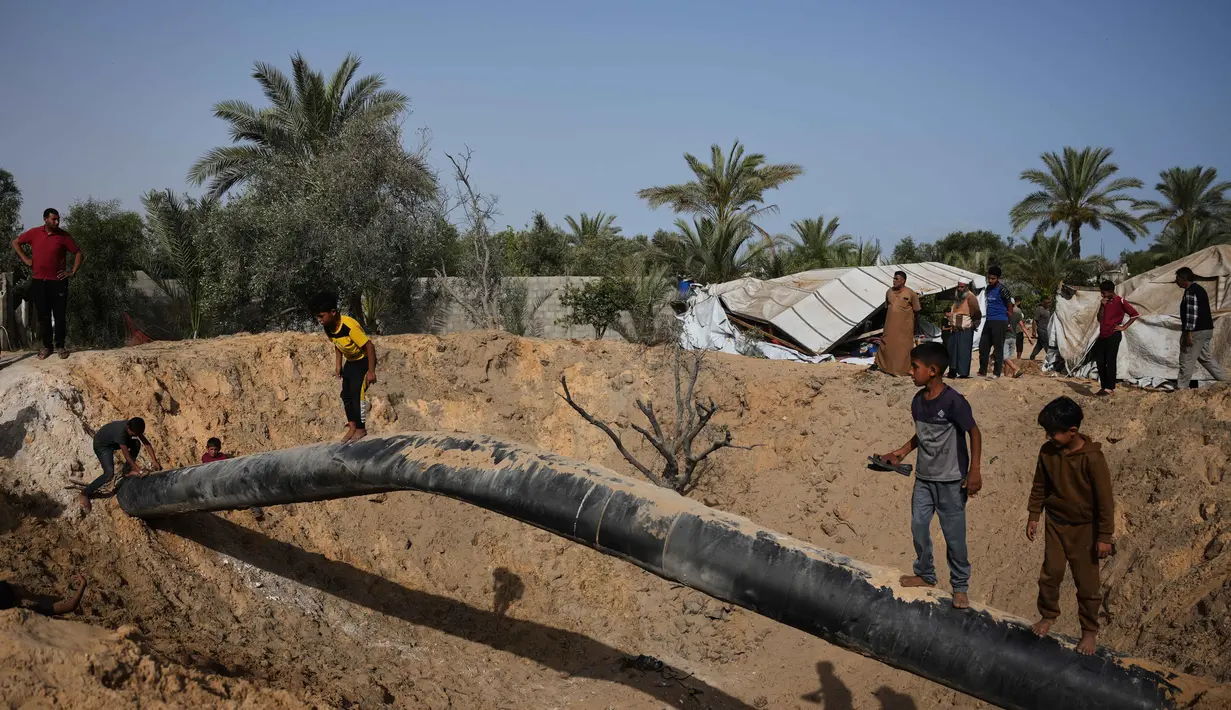 Warga Palestina memeriksa kerusakan akibat serangan Israel di Khan Younis, Jalur Gaza selatan, Selasa 19 Mei 2026. (AP Photo/Abdel Kareem Hana)