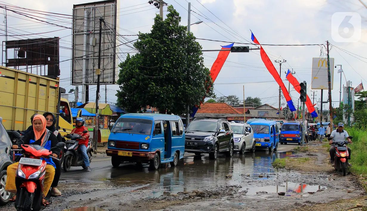 Kondisi Jalan Raya Bojonggede yang sudah berlubang sejak berbulan-bulan lalu, Kec. Bojonggede, Bogor, Jawa Barat, Sabtu (22/2/2020). Masyarakat sekitar dekat jalan berlubang mengeluhkan karena hingga saat ini jalananan belum juga di perbaiki. (merdeka.com/Magang/Muhammad Fayyadh)