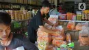 Pekerja menata dagangan kue kering di salah satu toko penjualan kue kering di kawasan Ciracas, Jakarta, Selasa (19/5/2020). Adanya pandemi covid-19 diakui para pedagang menyebabkan penjualan kue kering menjelang lebaran turun hingga 50 persen. (Liputan6.com/Immanuel Antonius)