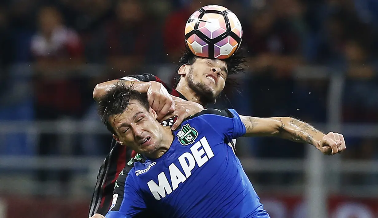 Bek AC Milan, Gustavo Gomez berebut bola dengan bek Sassuolo, Francesco Acerbi pada lanjutan liga Italia di San Siro, Milan (3/9). AC Milan menang dramatis atas Sassuolo dengan skor 4-3. (AFP Photo/Marco Bertorello)