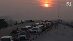 Kendaraan melintas saat matahari terbenam untuk keluar dari ruas Tol Batang-Semarang menuju jalur Pantura Batang-Kendal di Kali Kuto, Gringsing, Batang, Jawa Tengah, Senin (11/6). (Liputan6.com/Arya Manggala)