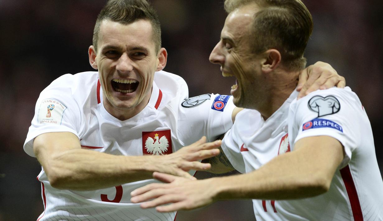 Pemain Polandia, Krzysztof Maczynski dan Kamil Grosicki, melakukan selebrasi usai cetak gol ke gawang Montenegro pada Kualifikasi Piala Dunia 2018 di Stadion National, Minggu (8/10/2017). Polandia menang 4-2 atas  Montenegro. (AP/Alik Keplicz)