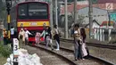 Sejumlah penumpang KRL Commuter Line terpaksa berjalan kaki menuju Stasiun Bojonggede, Bogor, Jawa Barat, Minggu (4/8/2019). Padamnya listrik di wilayah Jabodetabek mengakibatkan perjalanan KRL Commuter Line terhenti. (Liputan6.com/Helmi Fithriansyah)