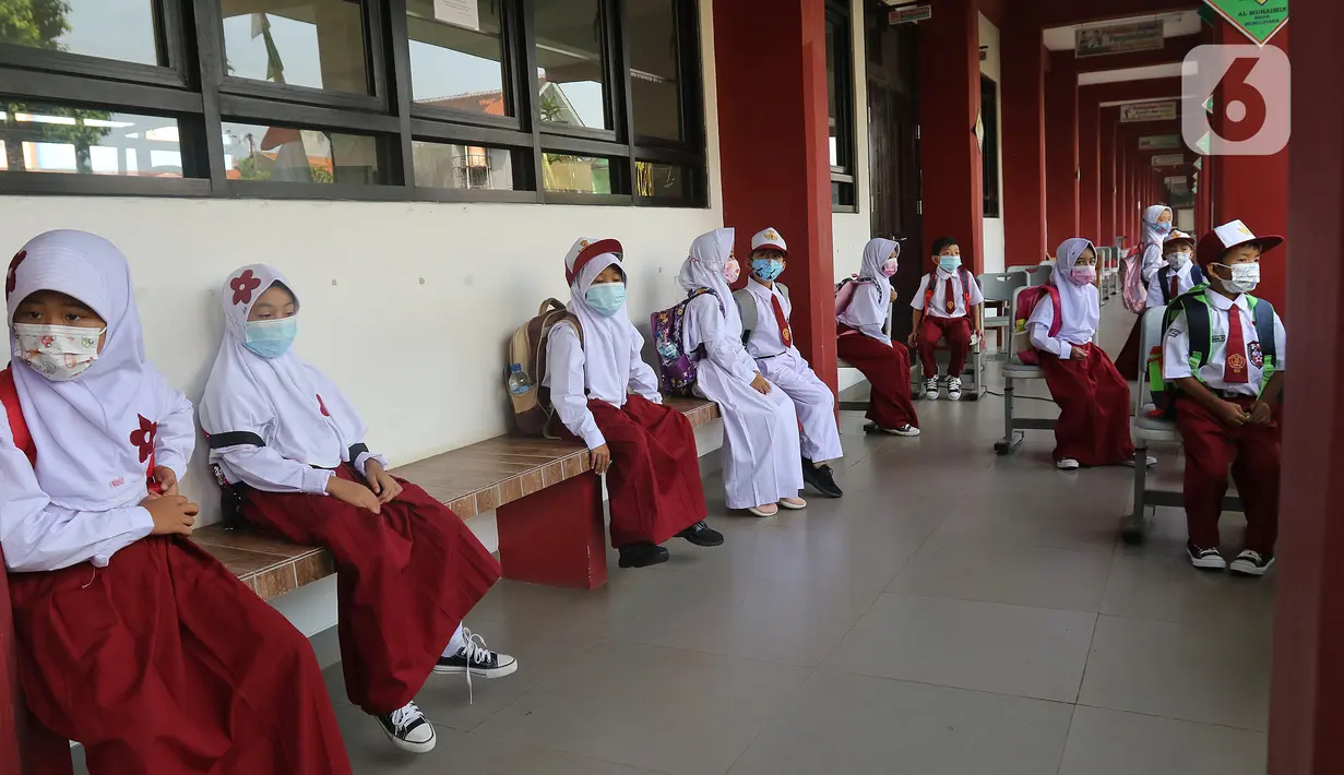 Sejumlah murid sedang menunggu jemputan di  SDN 05 Kalisari, Jakarta, Senin (30/8/2021). Pemprov DKI Jakarta menggelar pembelajaran tatap muka di tengah pandemi covid-19 mulai 30 Agustus 2021 secara terbatas dengan kapasitas 50 persen pada setiap satuan pendidikan. (Liputan6.com/Herman Zakharia)