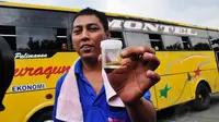 Seorang sopir bus memperlihatkan hasil tes urine di Terminal Pulo Gadung, Jakarta, Senin (21/7/14) (Liputan6.com/Faizal Fanani)