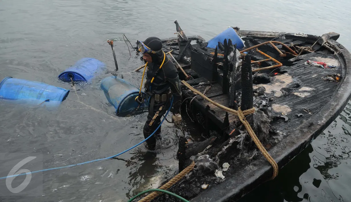 Petugas Basarnas dan Pol air menggunakan drum untuk mengangkat bangkai kapal Zahro Express di Pelabuhan Muara Angke, Jakarta, Rabu (4/1). Puluhan drum kosong dipasang di sekeliling kapal untuk mengangkat kapal perlahan-lahan. (Liputan6.com/Gempur M Surya)