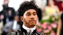Pembalap Mercedes, Lewis Hamilton saat menghadiri Met Gala 2019 di Metropolitan Museum of Art di New York, AS (6/5/2019). Pria 34 asal Inggris ini tampil dengan jas hitam memamerkan desain zig-zag perak dan celana yang senada. (AP Photo/Charles Sykes)