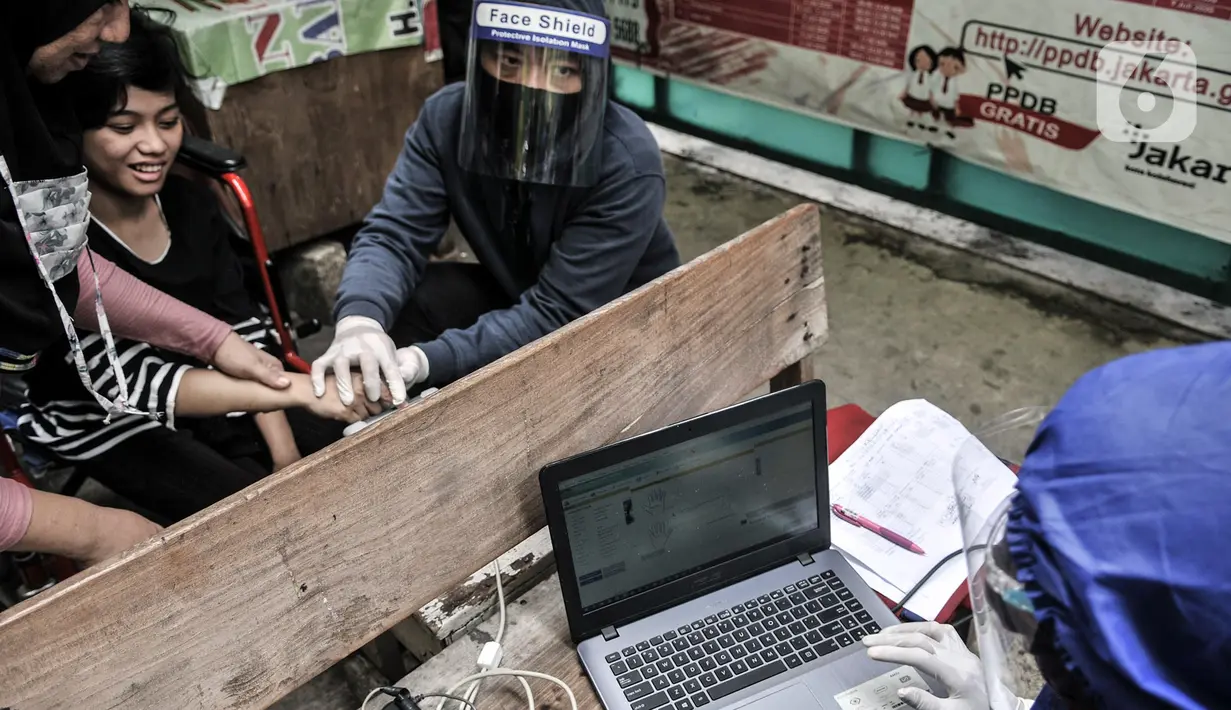 Petugas Disdukcapil Kota Jakarta Utara merekam E-KTP penyandang disabilitas di Pademangan Barat, Jakarta, Kamis (16/7/2020). Program jemput bola ini untuk memudahkan pelayanan administrasi kependudukan bagi penyandang disabilitas, jompo dan orang sakit di masa pandemi. (merdeka.com/Iqbal S. Nugroho)