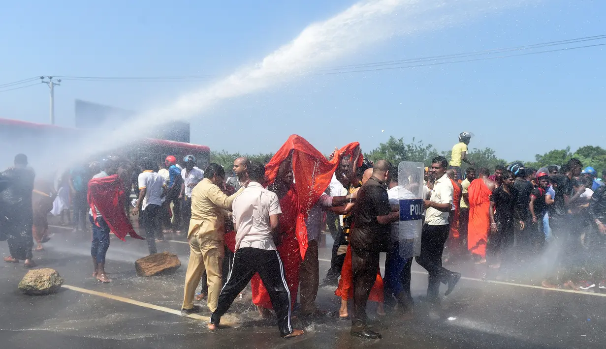Polisi Sri Lanka menembakan water canon untuk membubarkan aktivis dan biksu saat aksi protes di kota pelabuhan selatan Hambantota, Sri Lanka (7/1). (AFP/Ishara S. Kodikara)