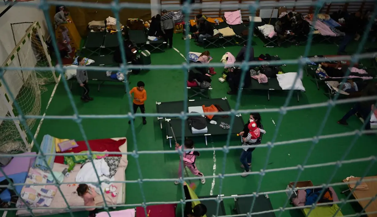 Pengungsi Ukraina terlihat di pusat pengungsian sementara di sekolah dasar setempat di Tiszabecs, Hongaria timur, 28 Februari 2022. Warga Hungaria bergegas ke perbatasan Ukraina untuk membantu pengungsi yang melarikan diri dari invasi Rusia. (Attila KISBENEDEK/AFP)