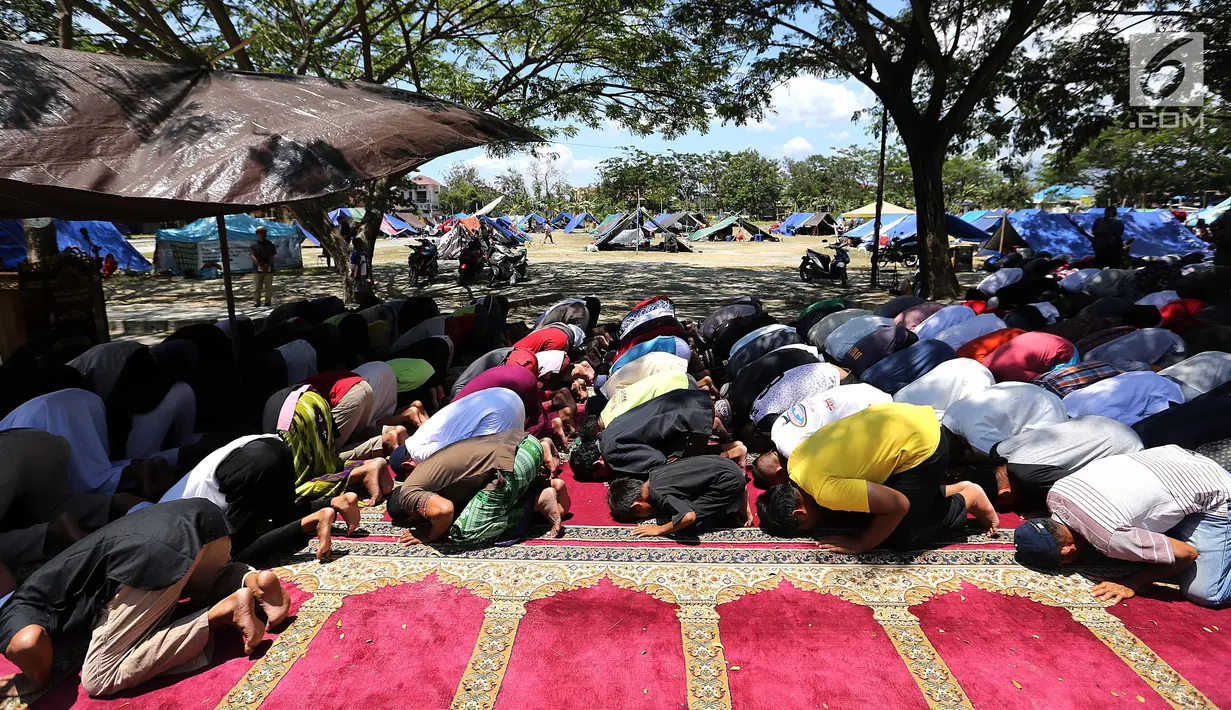 Ratusan pengungsi menjalankan salat Jumat pascagempa dan tsunami di Lapangan Masjid Agung Daru Salam, Palu, Jumat (5/10). Salat Jumat berlangsung khusyuk. (Liputan6.com/Fery Pradolo)