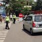Polisi mengatur lalu lintas saat pengendalian mobilitas ganjil genap untuk pengunjung TMII di Jalan Pintu 1 TMII, Jakarta, Sabtu (18/9/2021). Pembatasan mobilitas pada TMII dan Taman Impian Jaya Ancol dilakukan pada hari Jumat-Minggu mulai pukul 12.00-18.00 WIB. (Liputan6.com/Herman Zakharia)