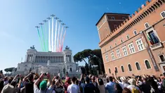 Warga menyaksikan aksi tim aerobatik Frecce Tricolori terbang mengeluarkan asap berwarna bendera Italia selama parade militer ulang tahun Hari Republik Italia ke-72 di Roma, Sabtu (2/6). (AP Photo/Claudio Peri)