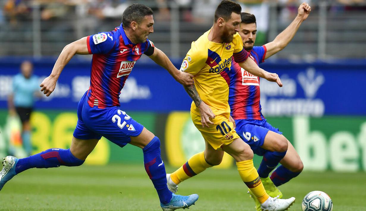 Striker Barcelona, Lionel Messi, berusaha melewati pemain Eibar pada laga La Liga 2019 di Stadion Ipurua, Sabtu (19/10). Barcelona menang 3-0 atas Eibar. (AP/Alvaro Barrientos)