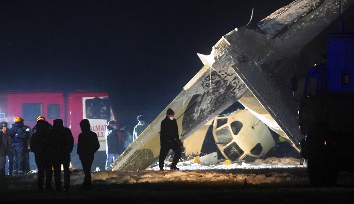 Pekerja darurat bekerja di samping pesawat Antonov An-26 yang jatuh di Bandara Almaty, Kazakhstan, Sabtu (13/3/2021). Pesawat Antonov An-26 tersebut terbalik dan terbakar di Bandara Almaty. (AP Photo/Vladimir Tretyakov)