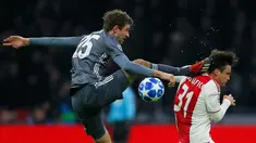 Gelandang Bayern Munchen Thomas Mueller (kiri) menendang kepala bek Ajax Amsterdam Nicolas Tagliafico dalam laga Grup E Liga Champions di Amsterdam, Belanda, Rabu (12/12). Mueller menendang Tagliafico dengan kaki kanannya. (AP Photo/Peter Dejong)