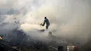 Warga berusaha memadamkan api dengan ember berisi air di Santa Ana, Asuncion, Paraguay, Kamis (19/8/2021). Api yang membakar kawasan pemukiman warga berpenghasilan rendah itu bermula dari orang-orang yang membakar sampah kemudian menjalar dan menghancurkan selusin rumah. (AP Photo/Jorge Saenz)