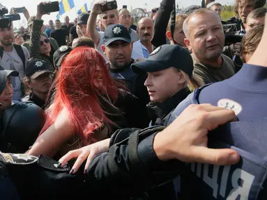 Aktivis perempuan Femen saat ditangkap polisi di titik cek Krakovets di perbatasan Ukraina-Polandia, di Ukraina, (10/9).  Aktivis ini menentang kembalinya mantan presiden Georgia Mikheil Saakashvili ke Ukraina. (AP Photo / Efrem Lukatsky)